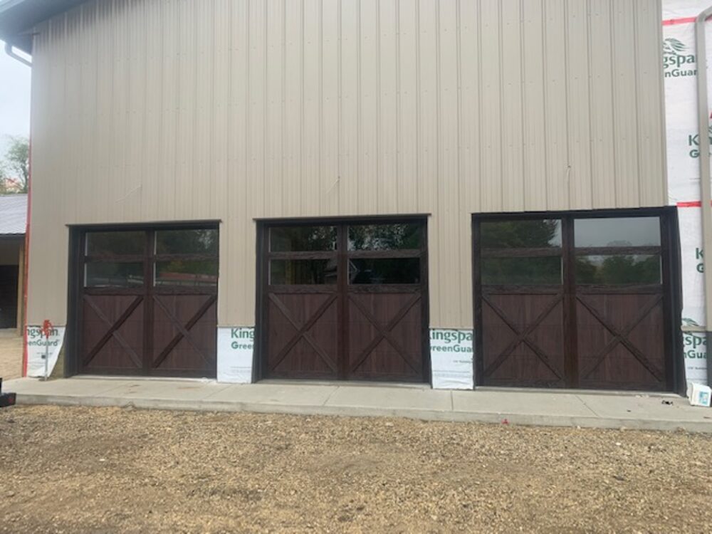 Dark carriage-style overhead doors on a metal pole building